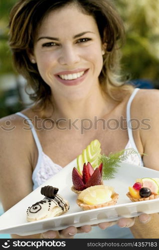 Portrait of a young woman holding a tray of food