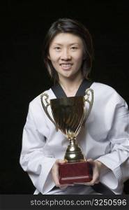 Portrait of a young woman holding a trophy