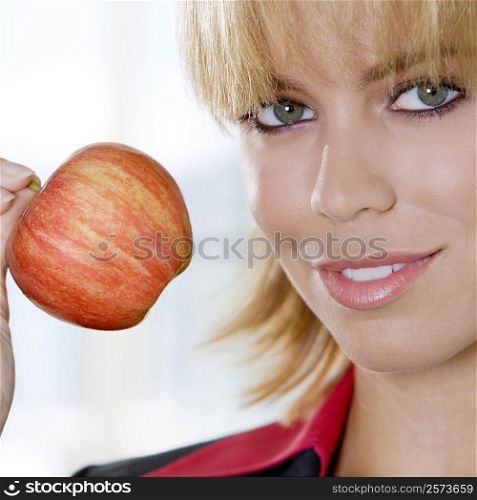 Portrait of a young woman holding an apple