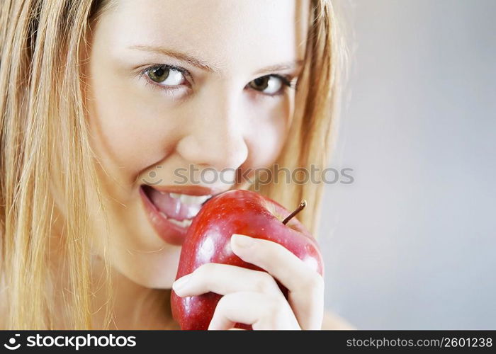 Portrait of a young woman holding an apple