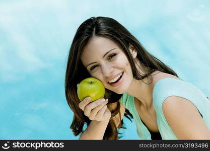 Portrait of a young woman holding an apple