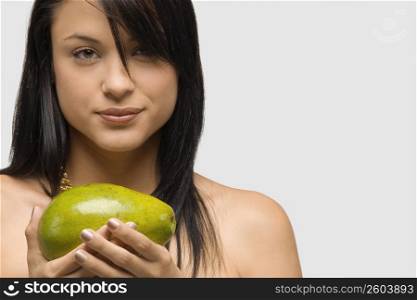 Portrait of a young woman holding an avocado