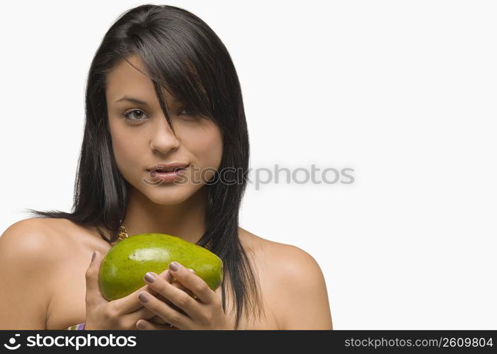 Portrait of a young woman holding an avocado