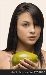 Portrait of a young woman holding an avocado