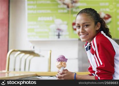 Portrait of a young woman holding an ice-cream and smiling