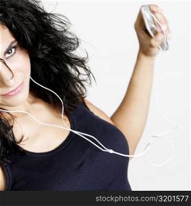 Portrait of a young woman holding an MP3 player