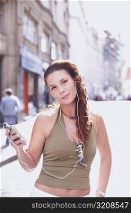 Portrait of a young woman holding an MP3 player