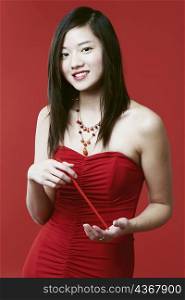 Portrait of a young woman holding chopsticks