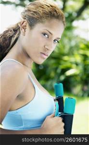 Portrait of a young woman holding dumbbells