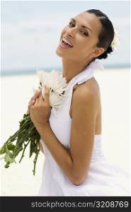 Portrait of a young woman holding flowers and laughing