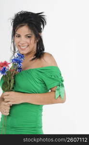 Portrait of a young woman holding flowers and smiling