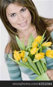 Portrait of a young woman holding flowers and smiling