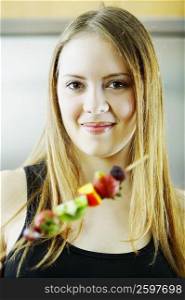 Portrait of a young woman holding fruit salad
