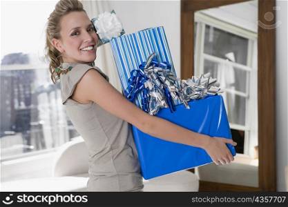 Portrait of a young woman holding gifts and smiling