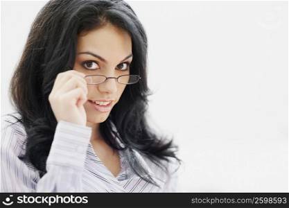 Portrait of a young woman holding her eyeglasses and smiling