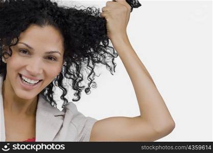 Portrait of a young woman holding her hair and smiling