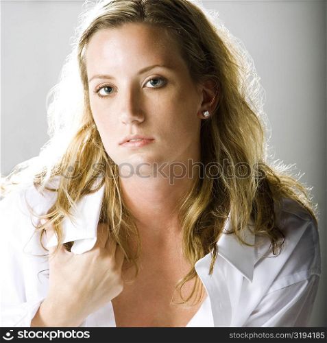 Portrait of a young woman holding her shirt collar