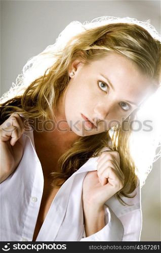 Portrait of a young woman holding her shirt collar