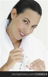 Portrait of a young woman holding nail polish and smiling