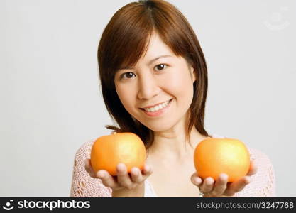 Portrait of a young woman holding oranges