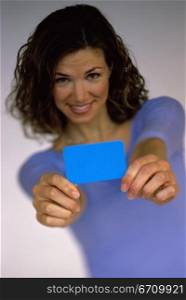 Portrait of a young woman holding out a credit card