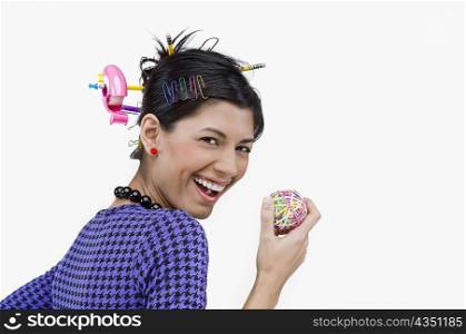 Portrait of a young woman holding rubber bands and smiling