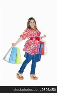 Portrait of a young woman holding shopping bags and smiling