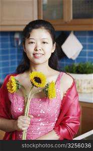 Portrait of a young woman holding sunflowers smiling