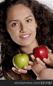 Portrait of a young woman holding two apples