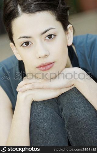 Portrait of a young woman hugging her knees