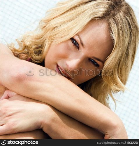 Portrait of a young woman hugging her knees