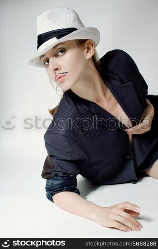 Portrait of a young woman in a hat with a fake mustache on white background