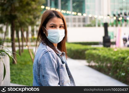 Portrait of a young woman in a medical mask for anti-coronavirus COVID-19 pandemic infectious disease outbreak protection in Public area. Concept of Virus pandemic and pollution  PM2.5 
