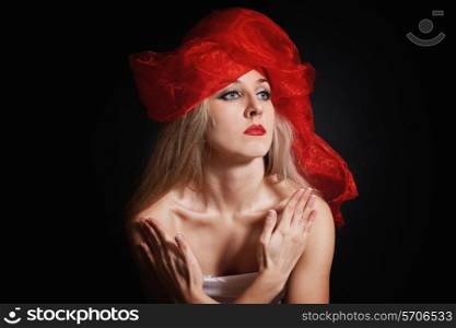 Portrait of a young woman in a red headdress on a black background