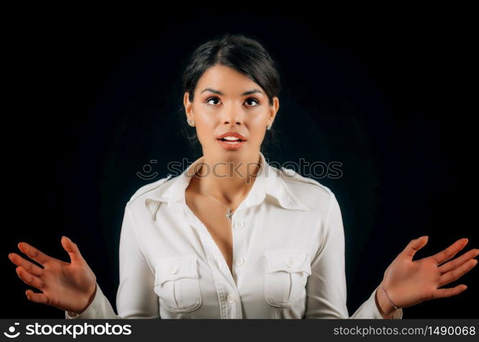 Portrait of a young woman in awe holding hands raised