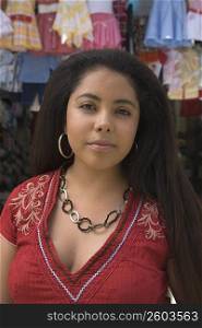 Portrait of a young woman in front of a clothing store