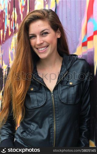 Portrait of a young woman in front of a colorful wall.
