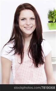 portrait of a young woman in kitchen. portrait of a happy smiling young woman in kitchen