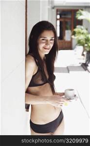 Portrait of a young woman in lingerie holding a cup of tea