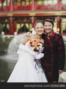 Portrait of a young woman in the wedding dress posing with another woman