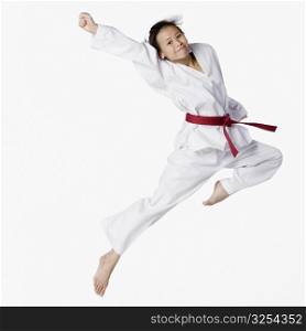 Portrait of a young woman jumping and practicing martial arts