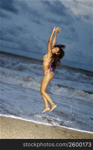 Portrait of a young woman jumping on the beach