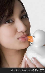 Portrait of a young woman kissing a toy duck