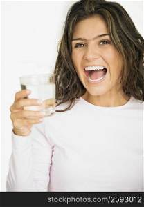 Portrait of a young woman laughing and holding a glass of water