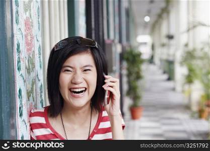 Portrait of a young woman laughing and talking on a mobile phone