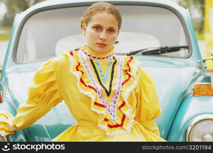 Portrait of a young woman leaning against a car