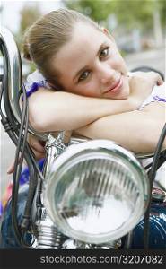 Portrait of a young woman leaning on a motorcycle