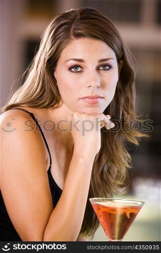 Portrait of a young woman leaning over a bar counter