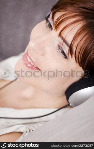 Portrait of a young woman listening music with headphones