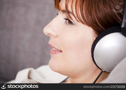 Portrait of a young woman listening music with headphones